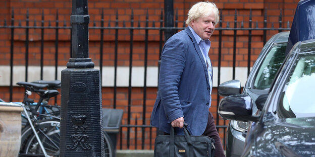Boris Johnson mit Aktentasche auf dem Weg zum Auto