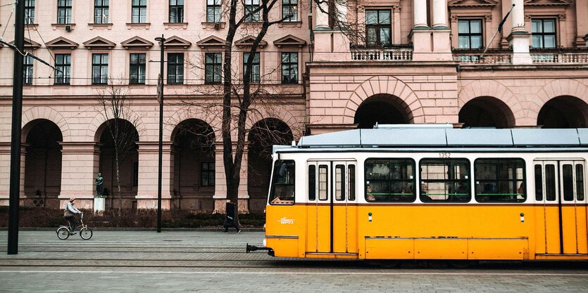 Eine Straßenbahn fährt an einer Radfahrerin vorbei