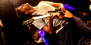 Dave Longstreth an der Gitarre auf der Bühne, den Kopf nach hinten geneigt, die Augen geschlossen