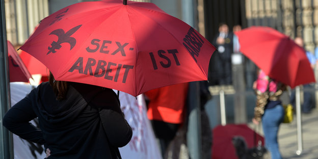 Mehrere Frauen halten vor dem Bundesrat Regenschirme in die Höhe, auf denen "Sexarbeit" steht