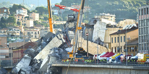 Rettungskräfte arbeiten in den Trümmern einer eingestürzten Autobahnbrücke