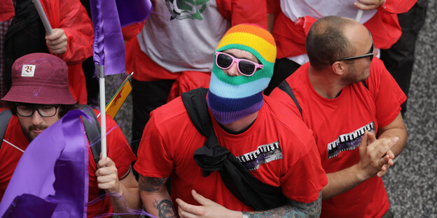 Ein Demonstrant mit einer bunten Sturmhaube und einer Sonnenbrille.