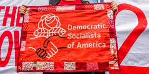 Mann hält Banner mit Democratic Socialists of America