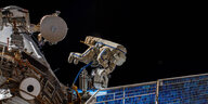 Ein Astronaut befestigt eine Antenne an der Internationalen Raumstation