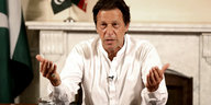 Imran Khan sitzt an einem Schreibtisch