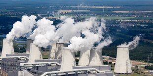 Dampfende Kühltürme, im Hintergrund einige Windkrafträder