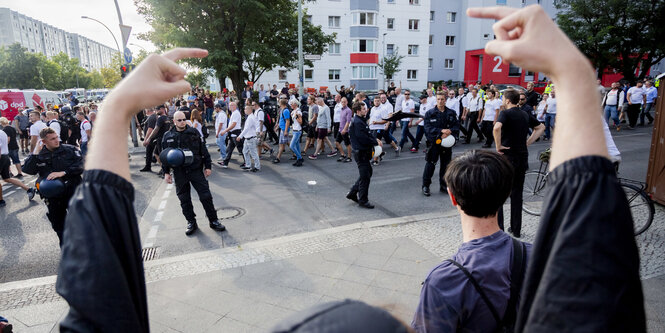 Ein Demonstrant zeigt zwei ausgestreckte Mittefinger in Richtung der Neonazi-Demo