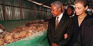 Kofi Annan und eine Frau vor Totenschädeln