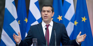 Alexis Tsipras vor einer griechischen und einer EU-Flagge