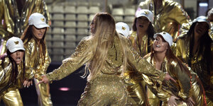 Jennifer Lopez und ihre Tänzerinnen treten in goldenen Klamotten bei den MTV Music Awards auf.