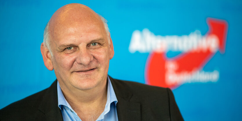 AfD-Politiker Franz Bergmüller vor einem Parteilogo