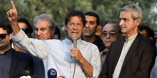 Imran Khan spricht in ein Mikro und hebt den einen Arm hoch