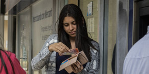 Eine Frau hält einen Geldschein in der Hand