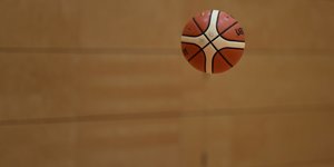 Ein Basketball fligt über dem Hallenboden