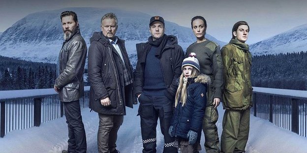Die Gruppe der Ermittler plus dem verschwundenen Mädchen posieren vor der Kamera in einer Schneelandschaft