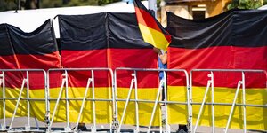 Eine Absperrung einer Veranstaltung ist von Deutschland-Fahnen gesäumt