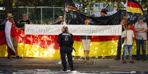 Demonstrierende bei einer Anti-Merkel-Demo tragen ein Transparent mit der Aufschrift „Wenn Unrecht zu Recht wird, wird Widerstand zur Pflicht“