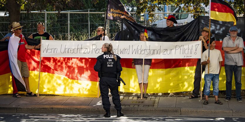 Demonstrierende bei einer Anti-Merkel-Demo tragen ein Transparent mit der Aufschrift „Wenn Unrecht zu Recht wird, wird Widerstand zur Pflicht“