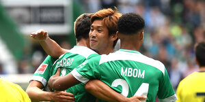 Vier Spieler von Werder Bremen umarmen sich beim Torjubel.