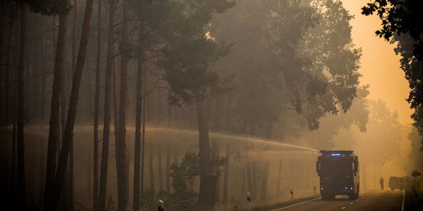 Auch ein Wasserwerfer der Polizei ist im Einsatz bei der Brandbekämpfung in einem Wald bei Treuenbrietzen.