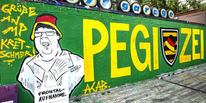 Eine grün gestrichene Wand, darauf der Schriftzug „Pegizei“ und das Abbild des sogenannten „Hutbürgers“, der sich über ein ZDF-Fernsehteam beschwert hatte