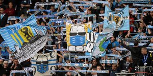 Fans des FC Chemnitz halten Transparente und Schals in die Höhe