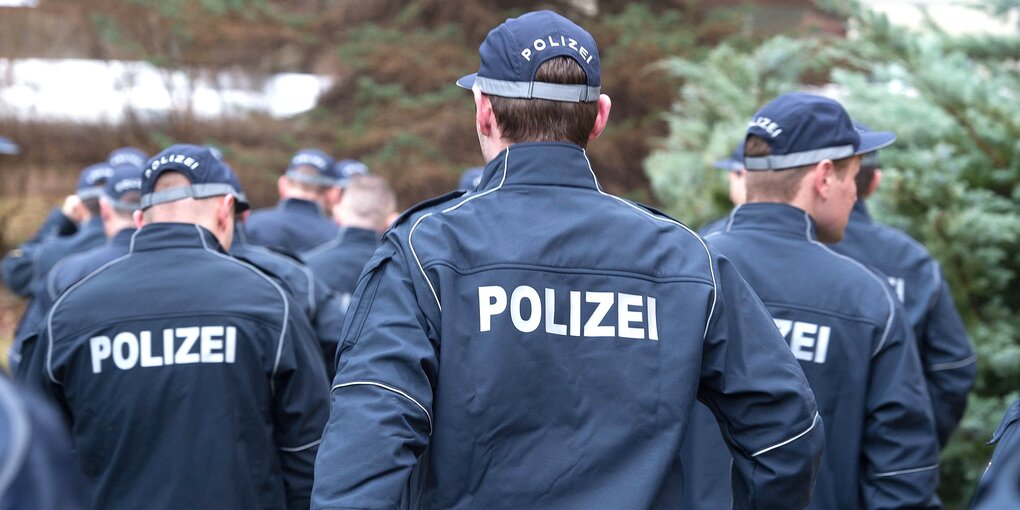 Die Rückenansicht von mehreren Polizisten mit Caps