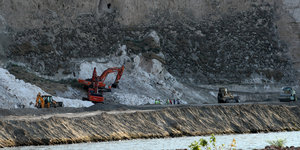 Bauarbeiten am Ilisu-Staudamm, mehrere Baggerfahrzeuge befinden sich vor einem steilen Abhang