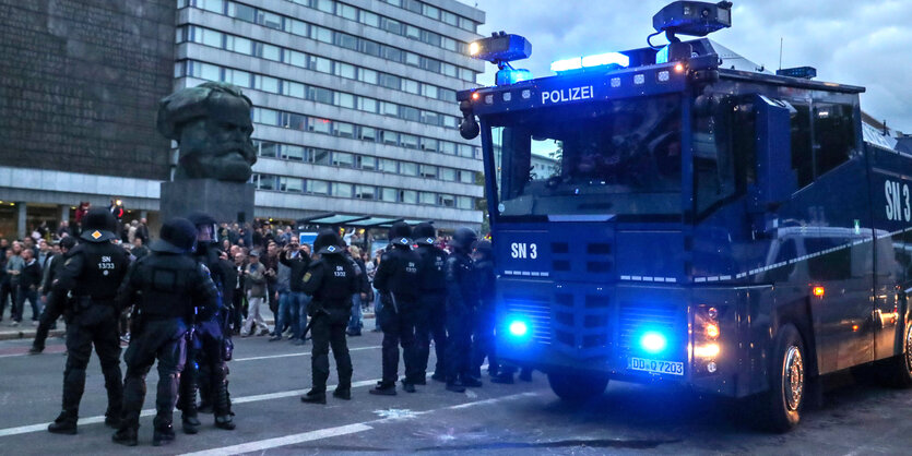 Polizisten mit Wasserwerfer