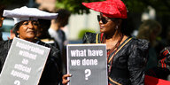 Bei Herero-Nama-Protest, zwei Frauen mit Schildern "What have we done?" und "Repatriation without an official apology?"