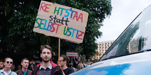 Menschen halten ein Schild hoch