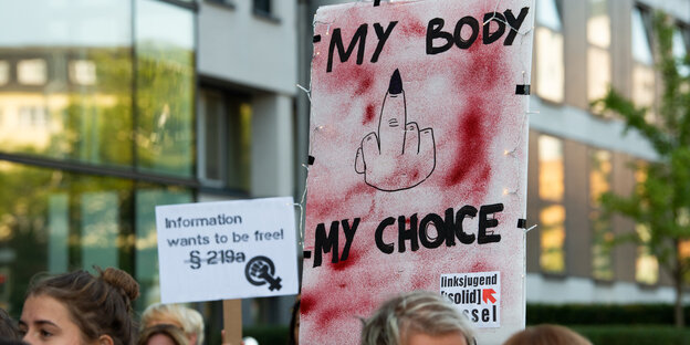 Ein Schild mit einem Mittelfinger und dem Spruch "My Body My Choice"