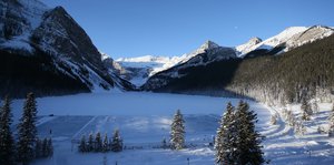 Winterlandschaft mit zugefrorenem See und weißen Berghängen