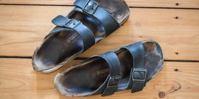 Ein paar blaue, ausgelatschte Gesundheitssandalen, Marke Birkenstock