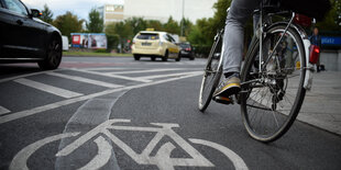 Radfahrer auf Radstreifen, links daneben Autos