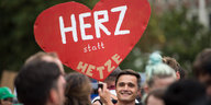 Ein Demonstrant trägt ein Plakat in Herzform in Chemnitz