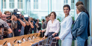 Sahra Wagenknecht steht an einem Tisch in der Bundespressekonferenz