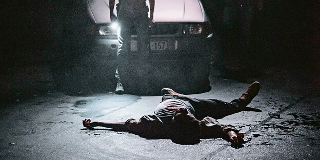 Der Ermordete liegt am Boden. Szenenbild aus der Inszenierung von Milo Rau
