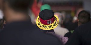 Ein Demonstrant mit Hut in Deutschlandfarben