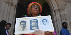Eine Frau hält ein Bild ihrer Eltern aus der Windrush-Generation in den Händen