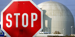 Ein großes Stopp-Schild steht vor der Kuppel eines AKW: Vattenfall klagt auf Entschädigung wegen des Atomausstiegs