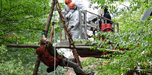 Kletterer der Polizei versuchen einen Umweltaktivisten, der an einem Holzpfahl im Hambacher Forst hängt, festzunehmen