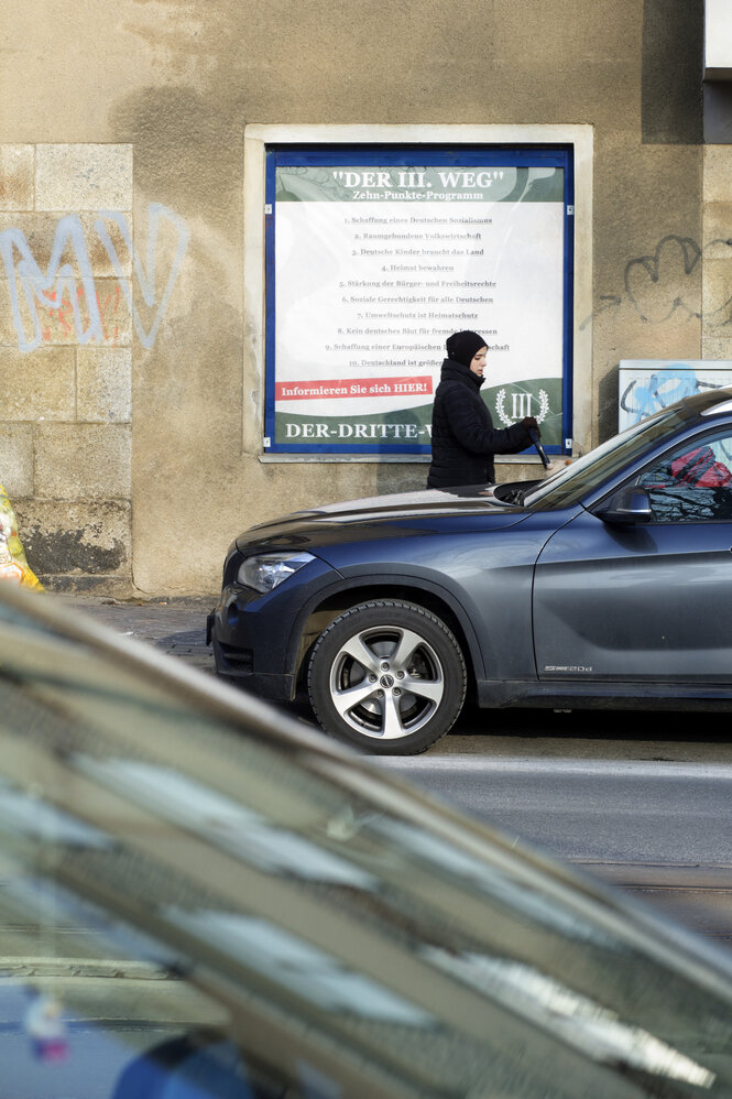 Im Schaufenster eines Gebäudes hängt ein Plakat der rechtsextremen Partei "Der III.Weg"