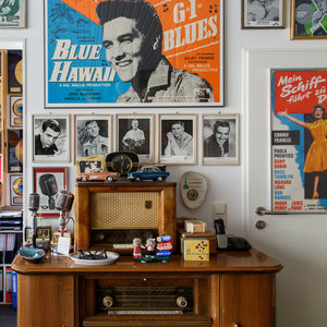 Ein Elvis-Poster hängt an einer Wand, darunter alte Musikabspielgeräte