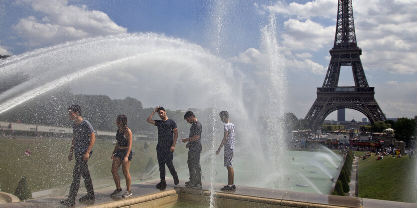 Junge Leute kühlen sich an einem Springbrunnen ab