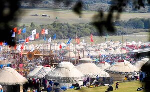 Die Besucher schlingeln sich zwischen traditionellen Zelten, Fahnen und ein Holzgerüst den Weg auf den World Nomad Games