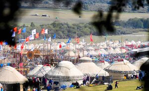 Die Besucher schlingeln sich zwischen traditionellen Zelten, Fahnen und ein Holzgerüst den Weg auf den World Nomad Games Die Besucher schlingeln sich zwischen traditionellen Zelten, Fahnen und ein Holzgerüst den Weg auf den World Nomad Games