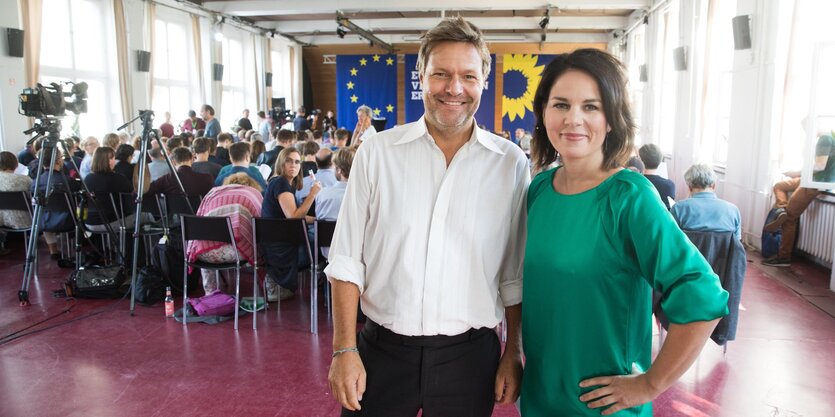 Das Vorstandsduo der Grünen, Annalena Baerbock und Robert Habeck, lächeln bei einer Pressekonferenz