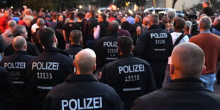 Polizisten stehen vor rechtsextremen Demonstranten