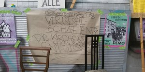 Eine Wandplakat mit der Aufschrift: Großbeerenstraße 17a. Vergesellschaften! Die Kir(s)chen enteignen